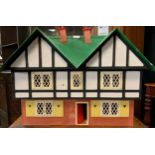 A modern two storey dolls house, green roof, black and white upper storey, plastic fittings, 55cm