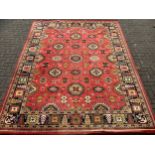 A large Turkish Amara woollen carpet, all over decorated with geometric medallions, red ground,
