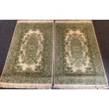 A Pair of Persian Isfahan type Rugs, the wool pile and silk carpets in subdued shades of green and