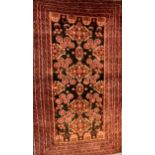 A Baluchi carpet in rich tones of black and claret, triple pole medallions, surrounded by