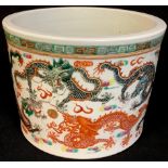 A Chinese export ware cylindrical jardiniere glazed in bright enamels with nine dragons and the