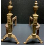 A pair of cast brass and iron fire dogs, urn finials, leafy feet, 31cm high, 37cm deep, 19th century