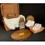 A wicker two handled basket, 58cm wide; lace table cloths; an early 20th century mahogany oval tray,