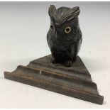 An early 20th century novelty inkwell, carved as an owl, glass eyes