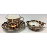 A Royal Crown Derby Imari 1128 pattern teacup and saucer; an 1128 tea strainer on stand, printed