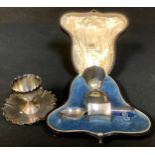 A George V silver eggcup, Sheffield 1916, a matched silver napkin ring and spoon, 97.2g, cased; a