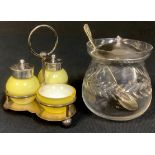 A George V silver three piece cruet set, the opaque cased yellow glass pepper and mustard pots