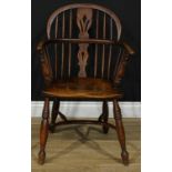 A 19th century ash and elm Windsor elbow chair, low hoop back, shaped and pierced splat, bowed mid-