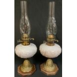 A pair Duplex brass pedestal oil lamps, milk glass fonts, 33cm high over fittings, c.1900