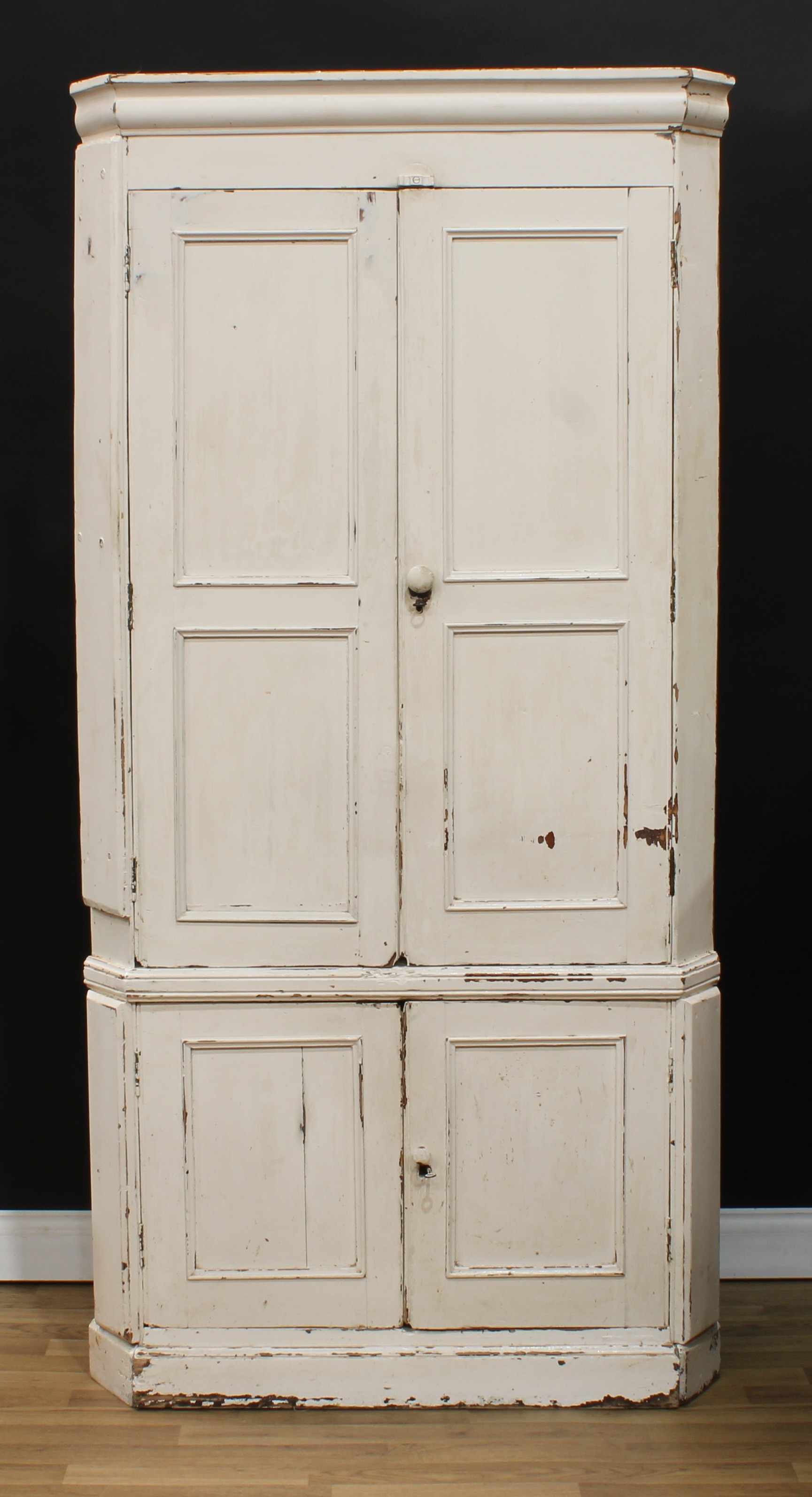 A 19th century painted pine floor-standing corner cupboard, moulded cornice above two pairs of panel