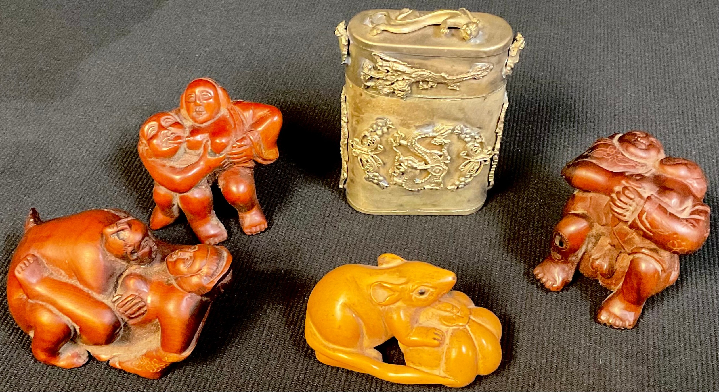 A Japanese boxwood netsuke, as a rat and melon; three others, erotica; a dragon tin (5)