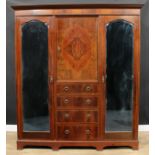 An early 20th century mahogany wardrobe, outswept cornice with faux-meandrous capital, above a