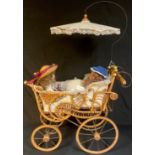 A 'Victorian' style cane and wicker child's pram and two bisque collectors dolls (3)