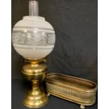 A brass oil lamp with etched glass globe; a brass jardinière