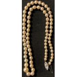 A single strand of graduated cultured pearls, the white gold clasp set with a diamond chip,