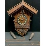 A German 'Black Forest' style cuckoo wall clock, 16cm dial with Roman numerals, carved architectural