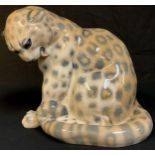 A Royal Copenhagen model of a seated leopard, tail curled, number 2555, 22cm, printed and painted