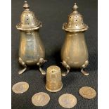 An associated pair of George VI silver pepper pots, Birmingham 1933 and 1938; a silver thimble,