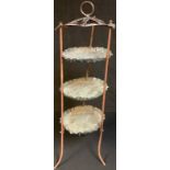 A Benson type three tier copper cake stand, the dishes engraved and embossed with scrolls, 83cm