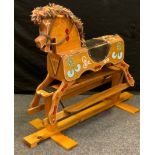 A hand painted rocking horse, plywood body, leather saddle, wool mane, saddle 63cm high, 88cm high