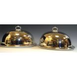 A pair of E.P.N.S meat domes and stands, gadrroned borders, 47cm wide