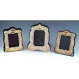 A Victorian style easel photograph frame of arched rectangular form embossed with cherubs, foliate