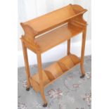 An early 20th century Cowtan & Sons book trough, splayed legs, casters, 74cm high, 52cm wide, with