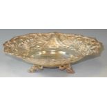 A Victorian style silver shaped circular bowl embossed with fruiting vine within leaf wrapped