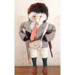 A novelty model, of an owl, in country attire, holding a shotgun and walking stick, 44cm high
