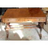 An early 19th century mahogany sofa table, crossbanded, cheval sabre legs, brass paw feet, turned