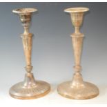 A composed pair of silver neo-classical table candle sticks, oval reeded nozzles, urnular sconces,