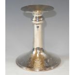 A contemporary silver candlestick, flared nozzle, cylindrical columns, hammered spreading circular