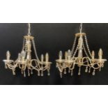 A pair of lustre glass five branch chandeliers, brushed steel scrolled arms, beaded strings and