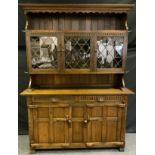 A 20th century Nigel/Rupert Griffiths style oak dresser, outswept cornice above three astragal