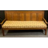 An 18th century oak six panel back settle, plain top rail, reeded panels, shaped scrolling arms,