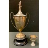 A silver two handled pedestal trophy cup and cover, shepherd and dog finial, engraved for the