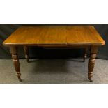 A Victorian mahogany extending dining table, canted rectangular top above reeded legs, casters,