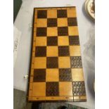 A wooden folding chess board containing complete turned chess set, 49cm wide