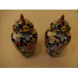 A pair of Enamel vases and covers with oriental flower pattern (21cm high) approx.