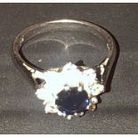 18ct white gold ring with central sapphire and 8 diamonds surrounding . 5.18 grams
