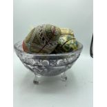 A thistle cut crustal glass bowl with a collection of decorative painted eggs