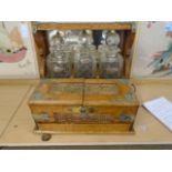 Beautiful oak cased Tantalus, 3 decanters- damage to inside of bottle stops, carved design, brass