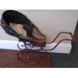 A vintage dolls nursery pram, - with larger wooden wheels and smaller metal caster wheels. Body made