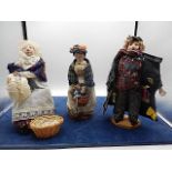 3 dolls with wooden faces, seated knitting lady, lady with basket and a trader
