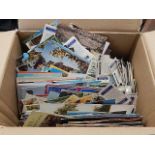 A box of mixed postcards and cigarette cards