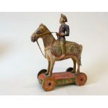 A 19c. hand painted wheeled wooden toy of Don Quixote riding his horse Rocinante, 20cm nose to