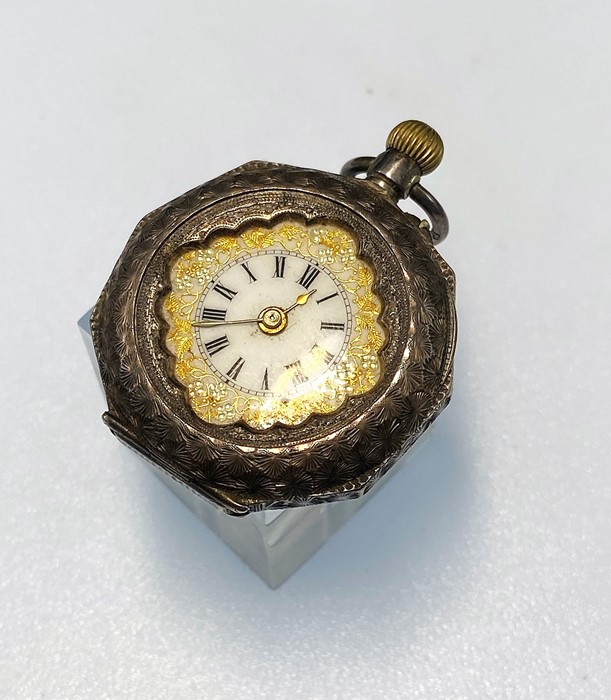 A ladies swiss open face pocket watch, white dial with Roman numerals and gilt scroll decoration,