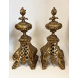 A pair of ornate Victorian brass fire dogs with finial design, 33cm tall
