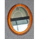 Oval bevelled mirror in walnut frame