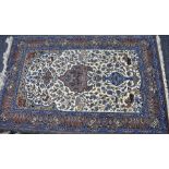 A Persian Qum (Ghom) hand knotted signed wool/silk pile rug. The central field has a cream